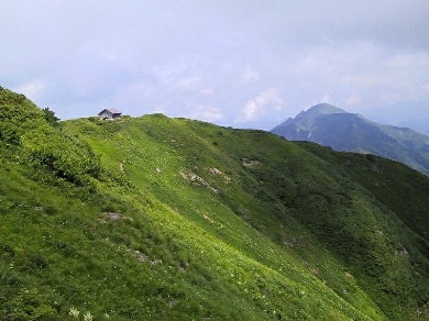 山頂直下から避難小屋と駒ヶ岳を見る
